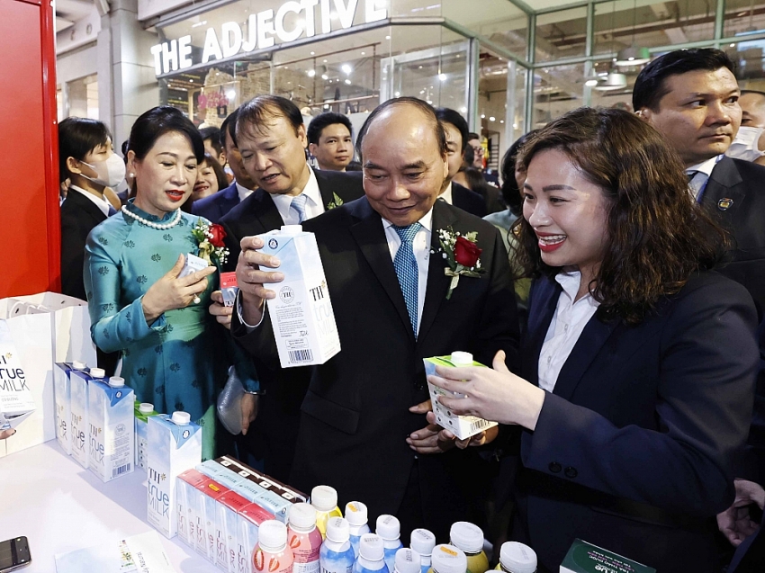 Chủ tịch nước Nguyễn Xuân Phúc cùng phu nhân và đoàn công tác dừng lại tại gian hàng của Tập đoàn TH nghe giới thiệu về các sản phẩm sữa tươi, đồ uống.