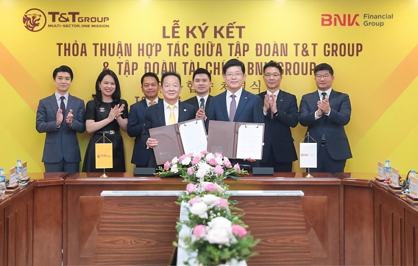 Ông Đỗ Quang Hiển, Chủ tịch UBCL Tập đoàn T&T Group (bên trái) và ông Bin Dae-in, Chủ tịch HĐQT kiêm TGĐ Tập đoàn Tài chính BNK (bên phải) trao thỏa thuận hợp tác với sự chứng kiến của đại diện lãnh đạo hai Tập đoàn.