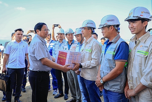 Thủ tướng Phạm Minh Chính tặng quà động viên cán bộ, công nhân trên công trường nút giao cao tốc Vân Phong - Nha Trang và Quốc lộ 26 - Ảnh: VGP/Nhật Bắc